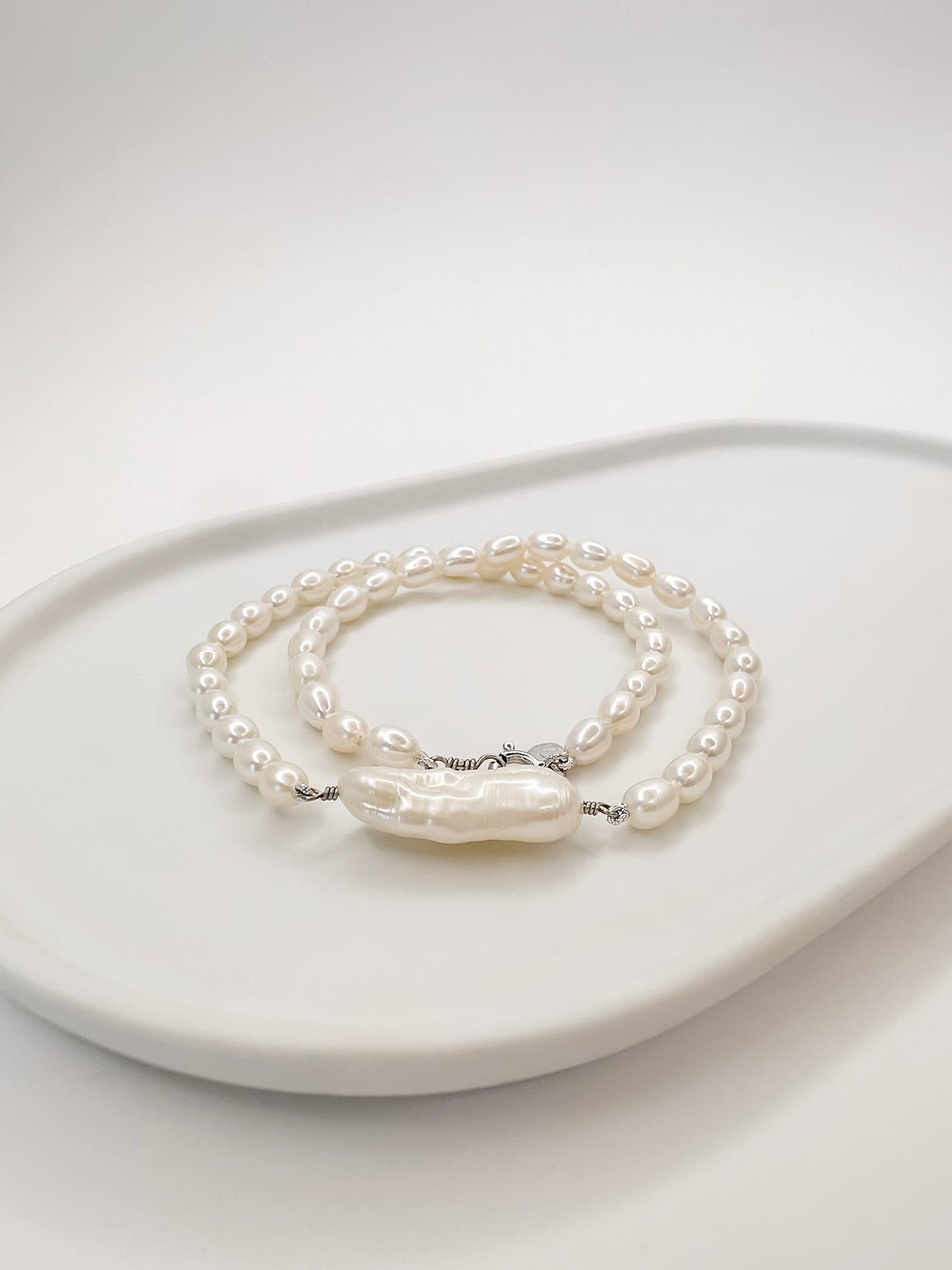 Colar no modelo Choker ou Gargantilha todo feito a mao com pérolas naturais ovais e uma em destaque em formato palito sendo essa perola barroca.