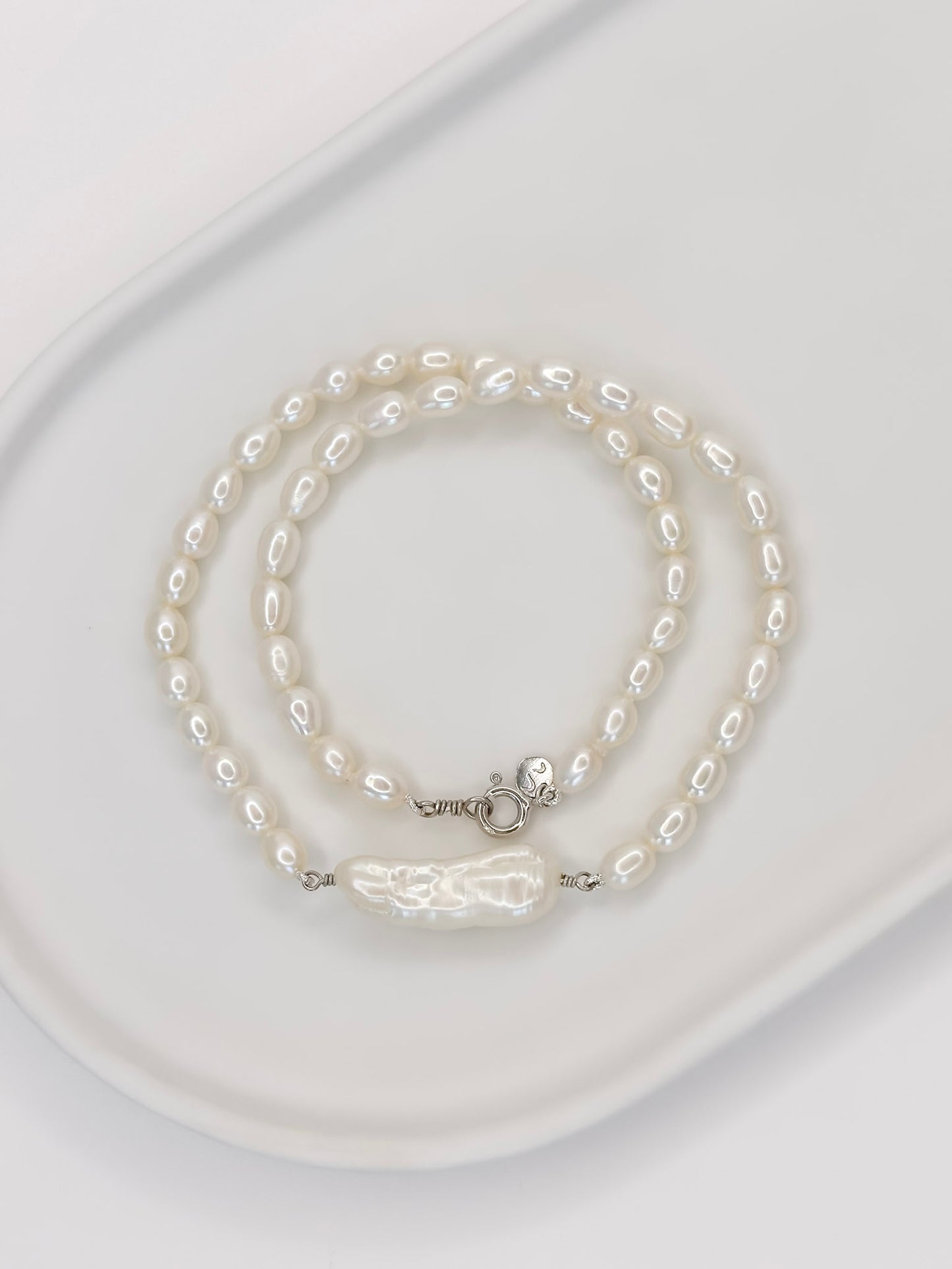 Colar no modelo Choker ou Gargantilha todo feito a mao com pérolas naturais ovais e uma em destaque em formato palito sendo essa perola barroca.