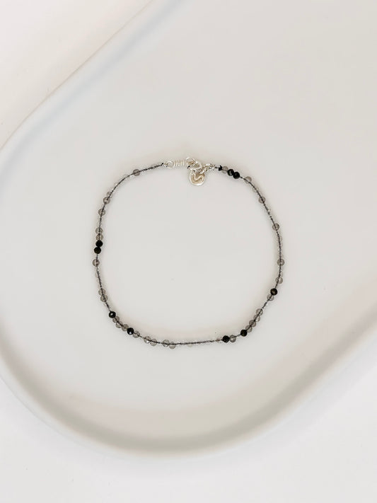 Pulseira produzida com quartzo rutilado natural com esferas lapidadas de 2mm e fecho bóia em prata apoiado em bandeja de ceramica branca e fundo branco.