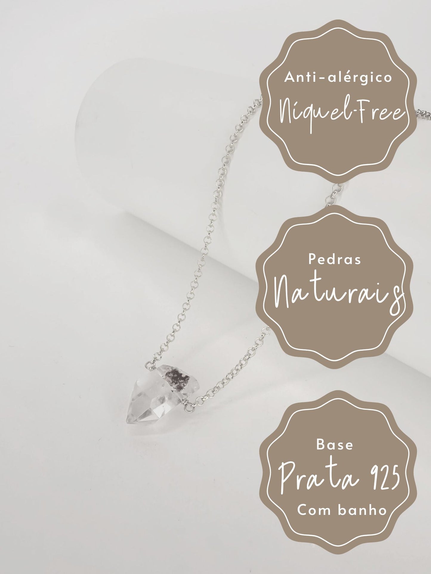 Foto preta e branca dos Beneficios e caracteristicas de Colar em corrente portuguesa de prata com banho de ouro apoiado em cilindro com uma ponta do cristal natural quartzo lodolita com fundo branco.